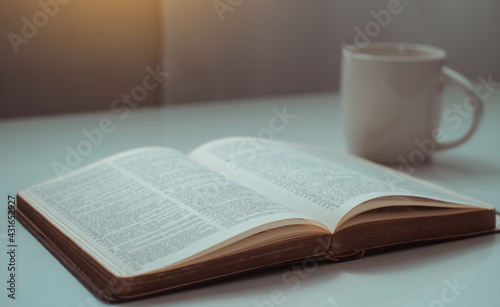 open bible with a cup of coffee for morning  with window light.