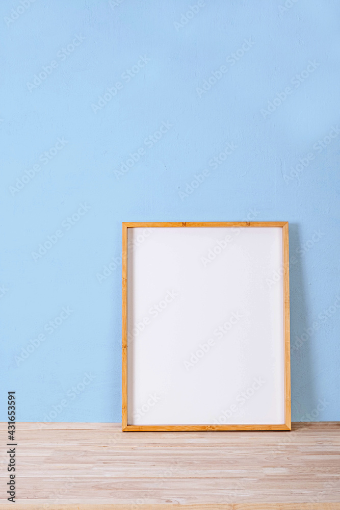 Fototapeta premium vertical wood frame mock up on wooden floor and Light blue background