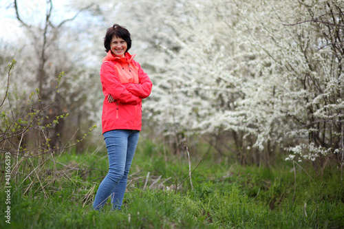 Beautiful mature woman posing for the camera in a blooming spring garden.  © Master Video