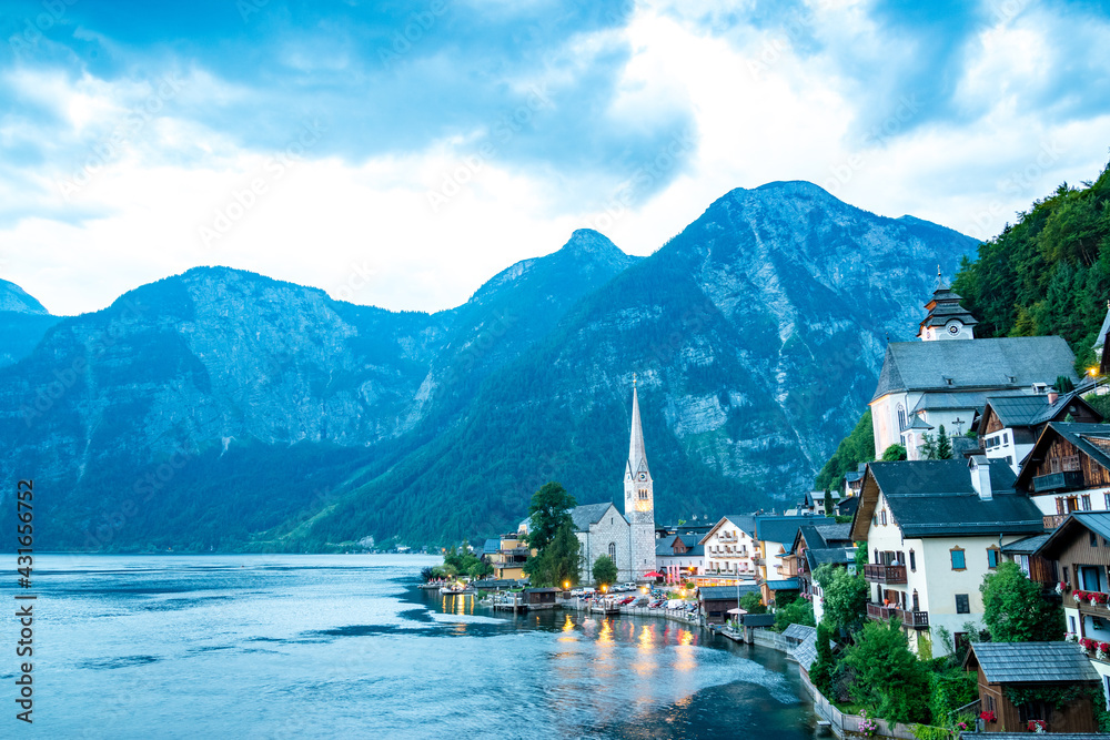 Scenic view of famous Hallstatt lakeside town reflecting in Hallstattersee lake in the Austrian Alps on a sunny day in summer, Salzkammergut region, Austria