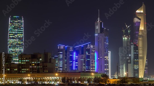 Skyline with Skyscrapers day to night timelapse in Kuwait City downtown illuminated at dusk. Kuwait City, Middle East photo