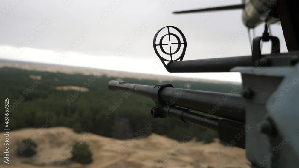 Bellicose machine gun with a cartridge tape fixed in a chopper flying in cloudy spring Bellicose machine gun with a cartridge tape fixed in a chopper flying in cloudy spring