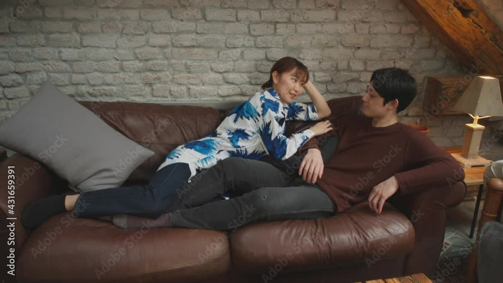 Young asian couple embracing on the couch. Young asian couple embracing on the couch.