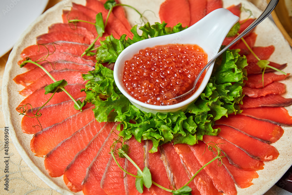 Lightly salted salmon and red caviar on a white plate. Close-up, selective focus Lightly salted salmon and red caviar on a white plate. Close-up, selective focus