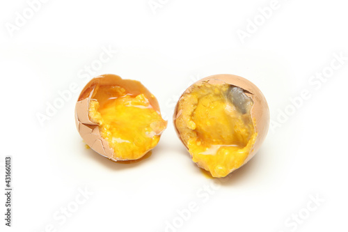 The broken rotten egg isolated in a white background. The yolk is already hard and the white is no more liquid. 