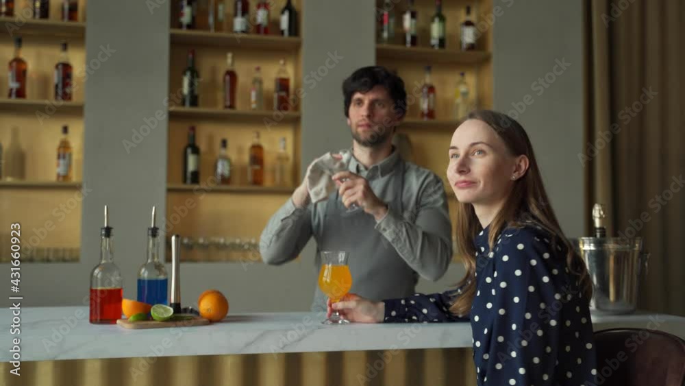 Smiling bartender and woman customer watching television in bar Smiling bartender and woman customer watching television in bar