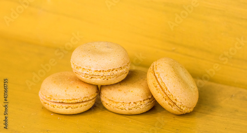 French yellow macaroons on a yellow background, concept yellow on yellow