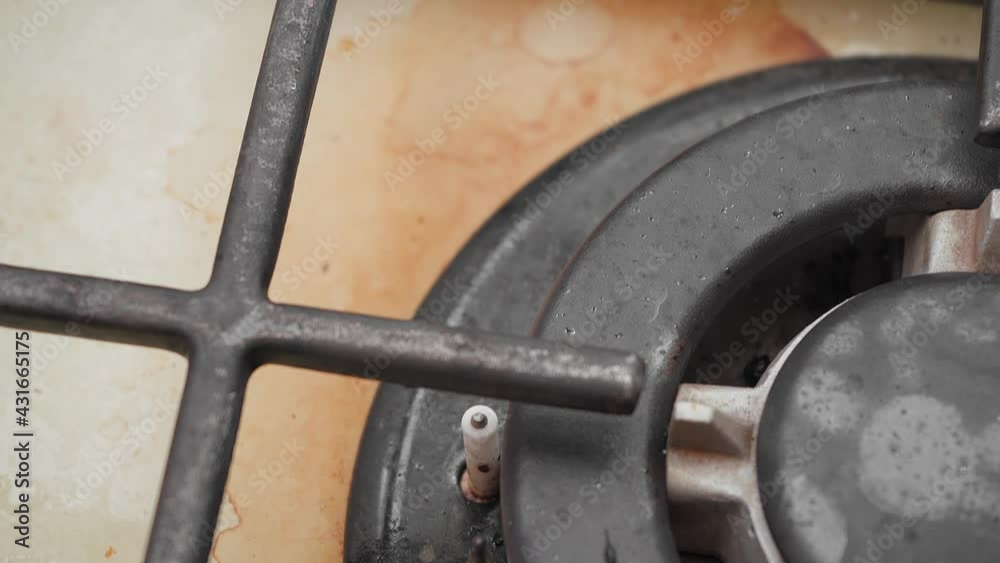 Burnt fat, dirt, and leftover food on an unwashed gas stove, close-up