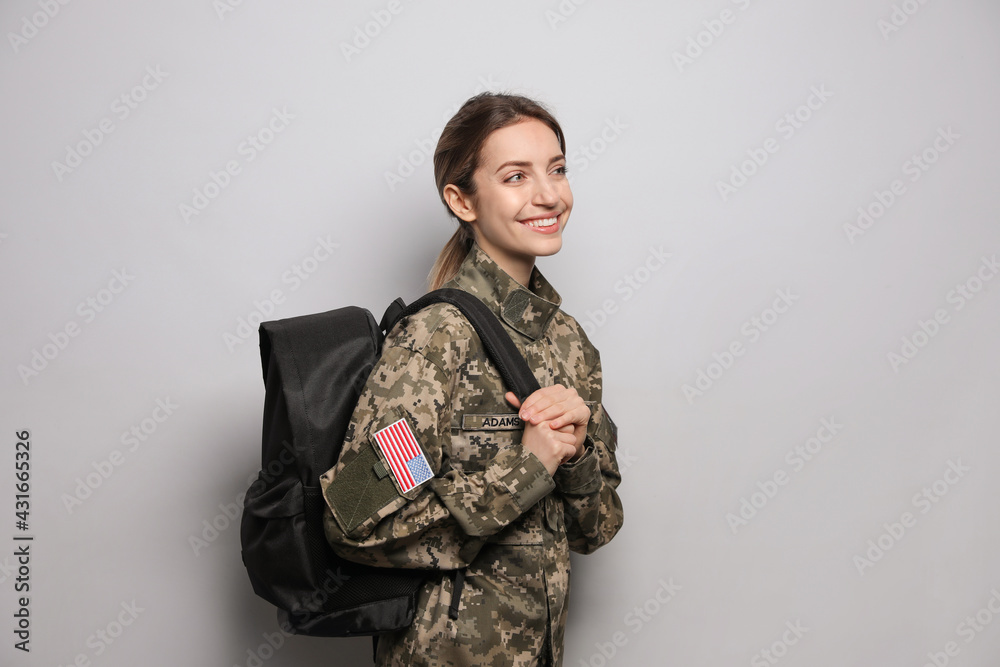 Female cadet with backpack on light grey background. Military education Female cadet with backpack on light grey background. Military education