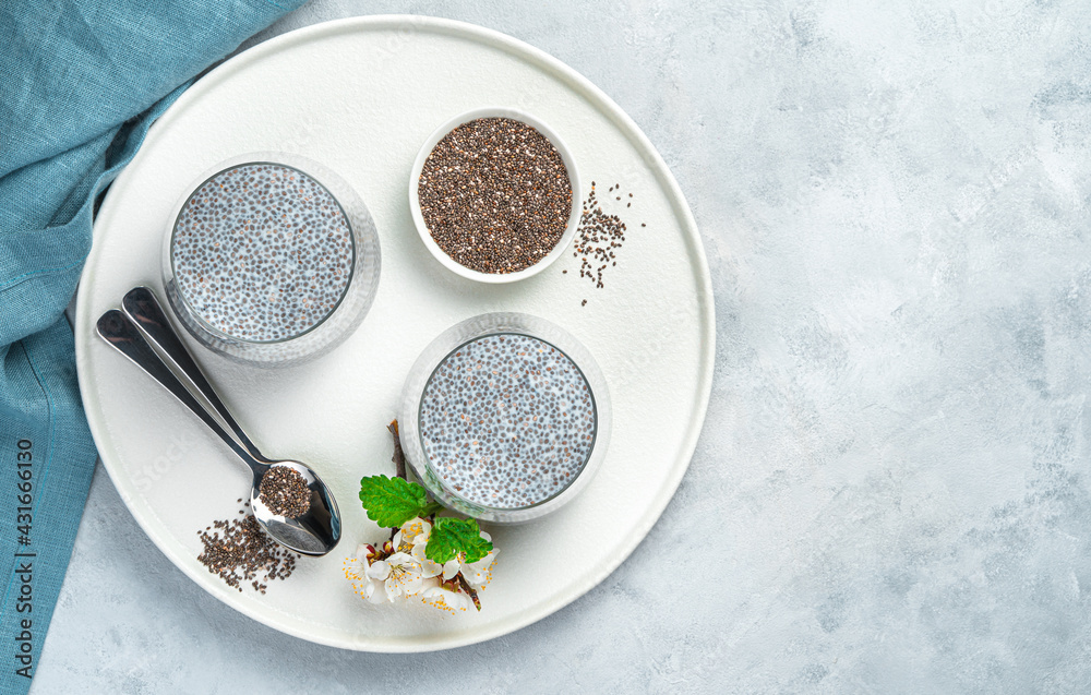 Dessert with chia seeds and coconut milk on a gray background. Top view, copy space. Dessert with chia seeds and coconut milk on a gray background. Top view, copy space.