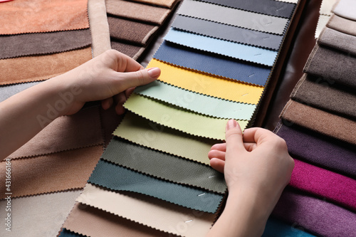 Woman choosing among colorful leather samples, closeup