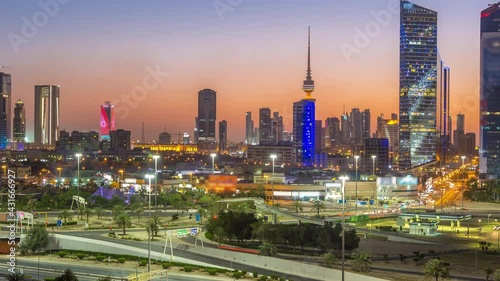 Skyline with Skyscrapers day to night timelapse in Kuwait City downtown illuminated at dusk. Kuwait City, Middle East photo