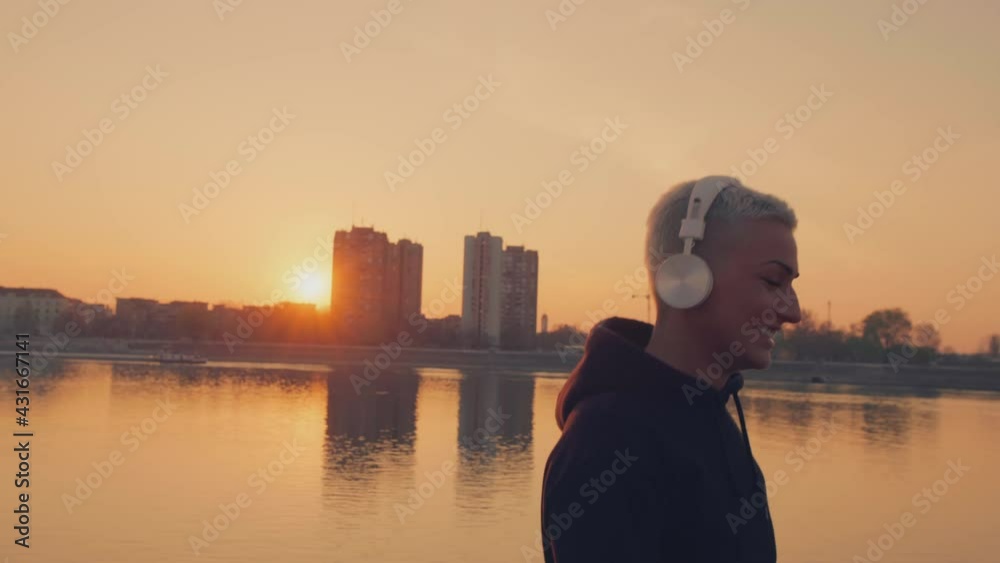 Athlete woman in a hoodie listening to the music.
