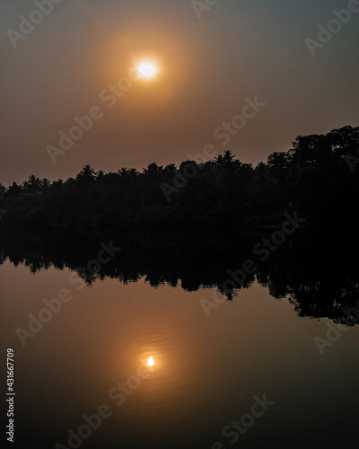 Photography photograph taken during the time of sunrise in kerala, India where we see sun s reflection in the river