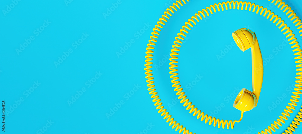 old fashioned yellow telephone handset with coiled cord and space for text. communications concept old fashioned yellow telephone handset with coiled cord and space for text. communications concept