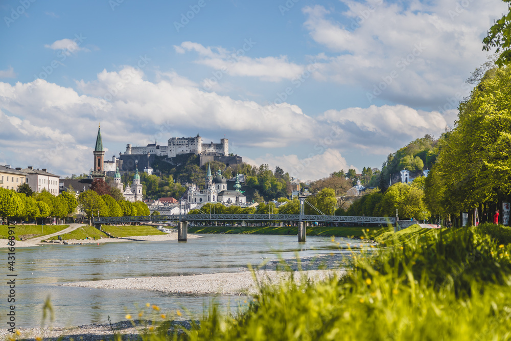 Salzburg summer time: Panoramic city landscape with Salzach with green grass and historic district