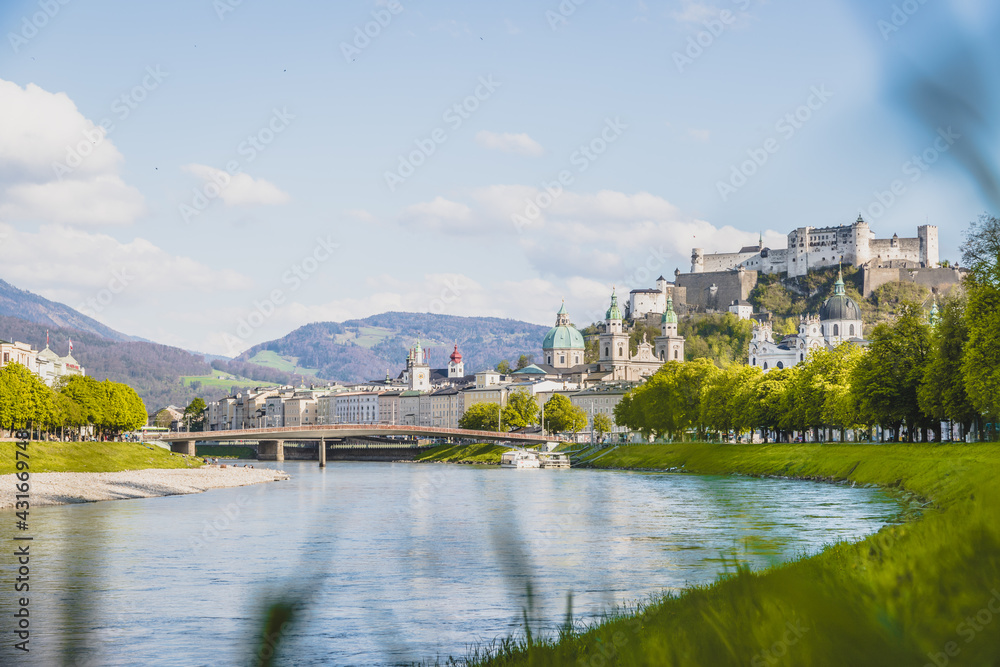 Fototapeta premium Salzburg summer time: Panoramic city landscape with Salzach with green grass and historic district