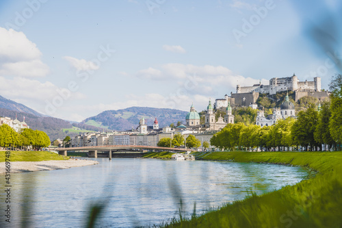Salzburg summer time: Panoramic city landscape with Salzach with green grass and historic district