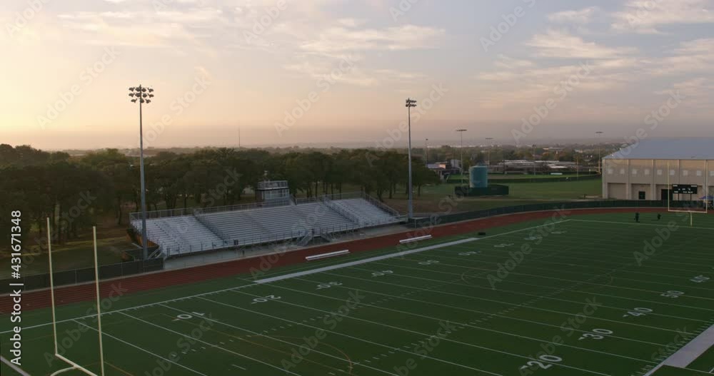 High angle aerial of an American track and football field at dawn in Dallas Texas.