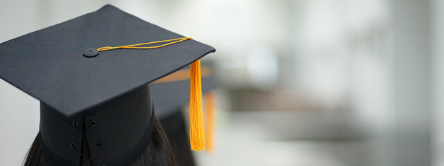 Young happy Asian woman university graduate in graduation gown and cap in the college campus. Education stock photo