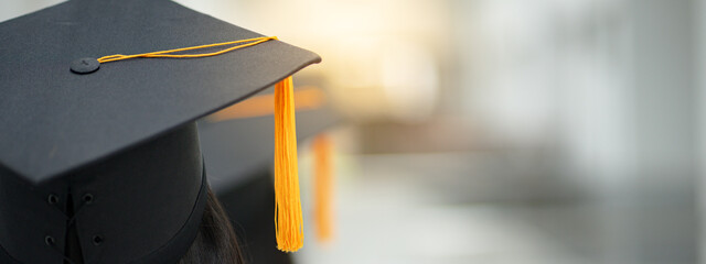 Young happy Asian woman university graduate in graduation gown and cap in the college campus. Education stock photo