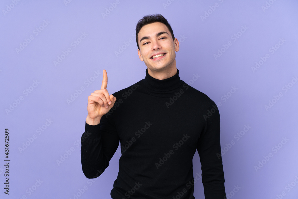 Young caucasian handsome man with turtleneck sweater isolated on purple background showing and lifting a finger in sign of the best Young caucasian handsome man with turtleneck sweater isolated on purple background showing and lifting a finger in sign of the best