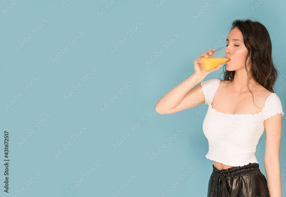 Caucasian woman with orange and orange juice isolated on blue Caucasian woman with orange and orange juice isolated on blue