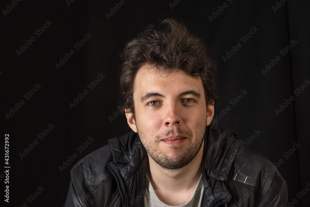 Obraz premium Portrait of a young dark-haired man with bokeh effect on a dark background
