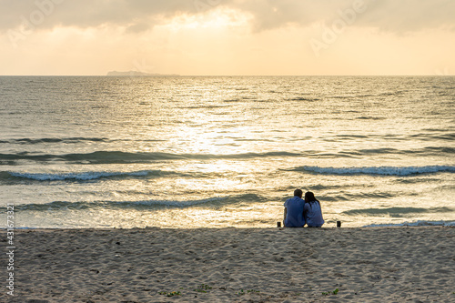 Romantic couple on Thung Wua Laen beach at sunrise. Scenery in Chumphon province, Southern Thailand. photo