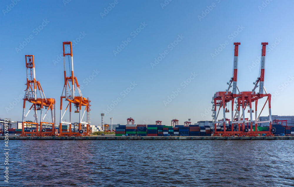 Cranes and cargo container at seaside. They are at sea port in Osaka bay, Japan.