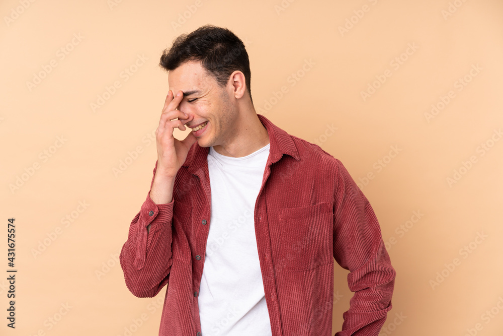 Young caucasian handsome man isolated on beige background laughing Young caucasian handsome man isolated on beige background laughing