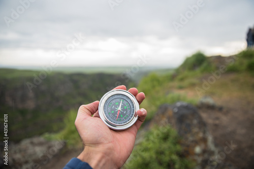 man holding compass in nature