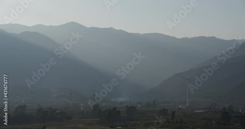 Sun beam shinning on a wind turbine located in the valley of Sichuan, China photo