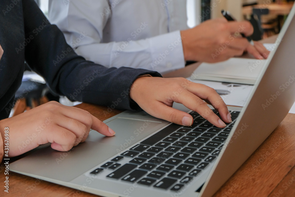 Working by using a laptop computer on wooden table. Hands typing on a keyboard.technology e-commerce concept. Working by using a laptop computer on wooden table. Hands typing on a keyboard.technology e-commerce concept.