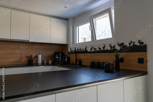 Fototapeta Naklejka Na Ścianę i Meble -  interior view of a modern and elegant kitchen with white cupboards and black tiles