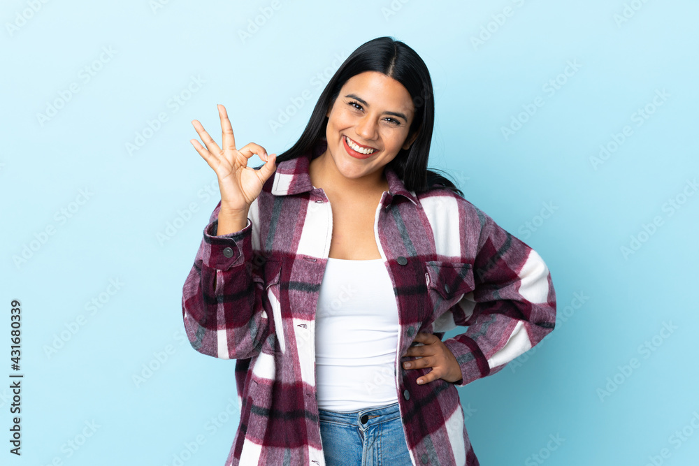 Young latin woman woman isolated on blue background showing ok sign with fingers Young latin woman woman isolated on blue background showing ok sign with fingers