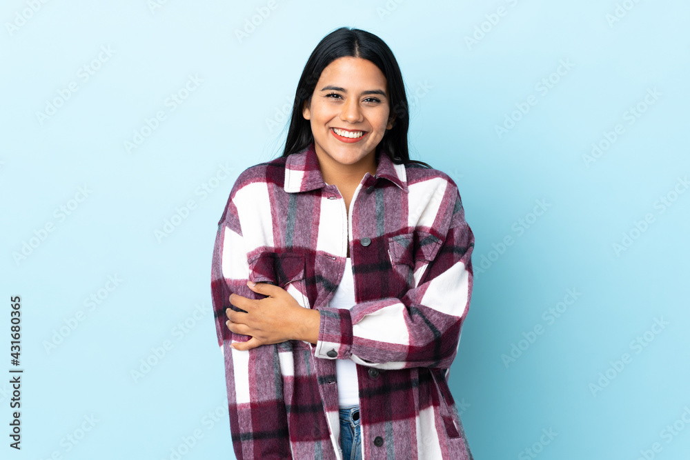 Young latin woman woman isolated on blue background laughing