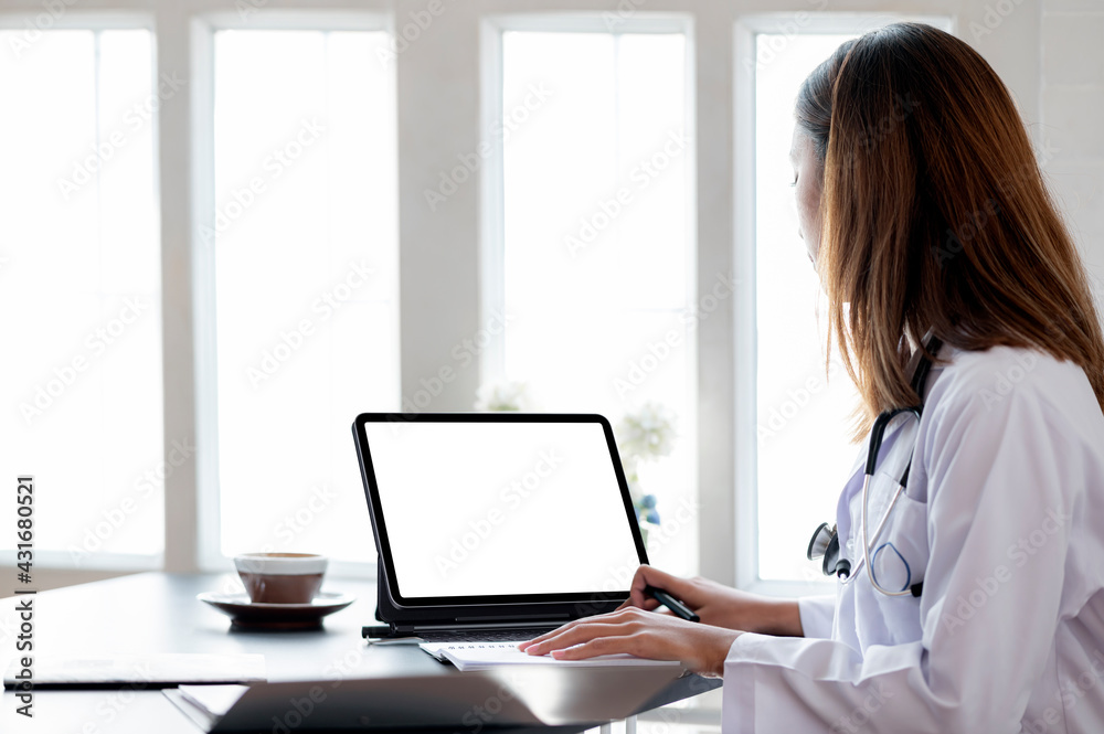 Female doctor working and typing on laptop computer keyboard at medical office in clinic. Female doctor working and typing on laptop computer keyboard at medical office in clinic.