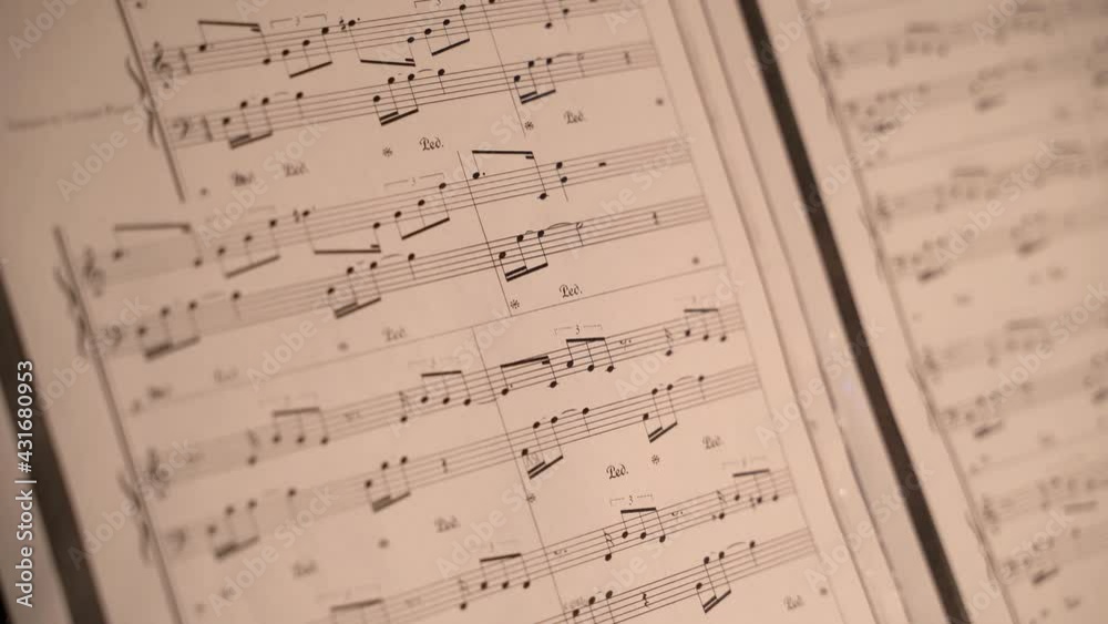 musical notation. sheet music near the piano. a girl plays classical music musical notation. sheet music near the piano. a girl plays classical music