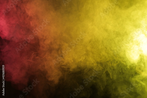 Smoke in red-yellow light on black background