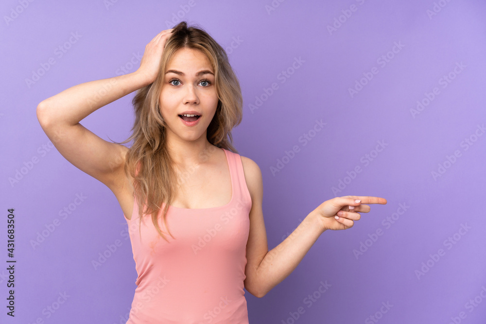 Teenager Russian girl isolated on purple background surprised and pointing  finger to the side Stock Photo | Adobe Stock