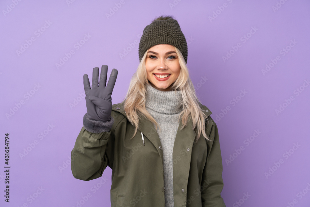 Teenager blonde girl with winter hat over isolated purple background happy and counting four with fingers Teenager blonde girl with winter hat over isolated purple background happy and counting four with fingers