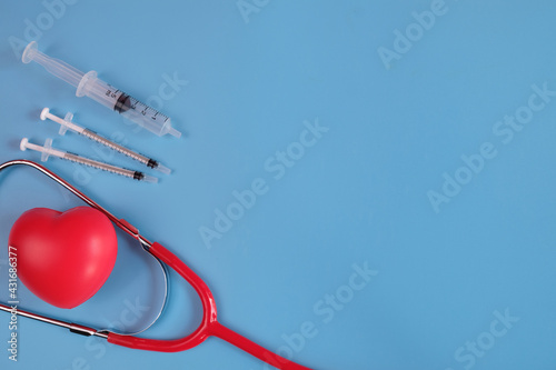 Red heart and medical equipment on blue background photo