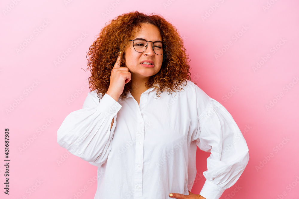 Young latin curvy woman isolated on pink background covering ears with hands. Young latin curvy woman isolated on pink background covering ears with hands.
