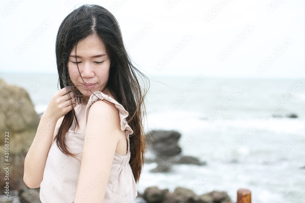 Happiness of asian woman is standing on wooden bridge Extending into the sea on Holiday. She is smiling in the natural wind and sea ​​breeze on vacation and summertime in Thailand