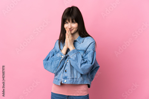 Young Ukrainian woman isolated on pink background keeps palm together. Person asks for something © luismolinero