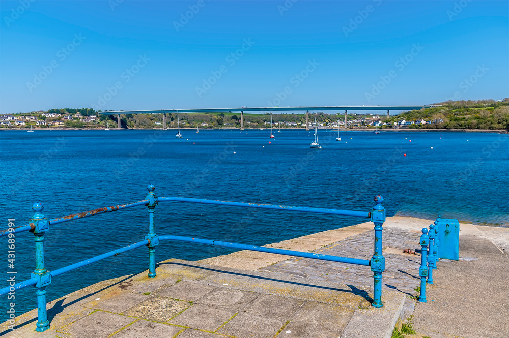 A view towards the Cleddau bridge across the Haven from the shoreline at Pembroke Dock, Pembrokeshire, South Wales on a sunny day