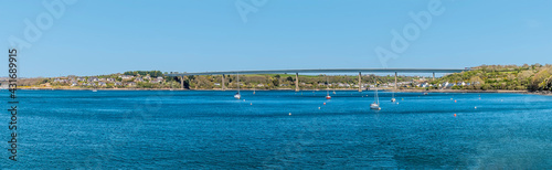 A panorama view towards the Cleddau bridge across the Haven from the shoreline at Pembroke Dock, Pembrokeshire, South Wales on a sunny day © Nicola