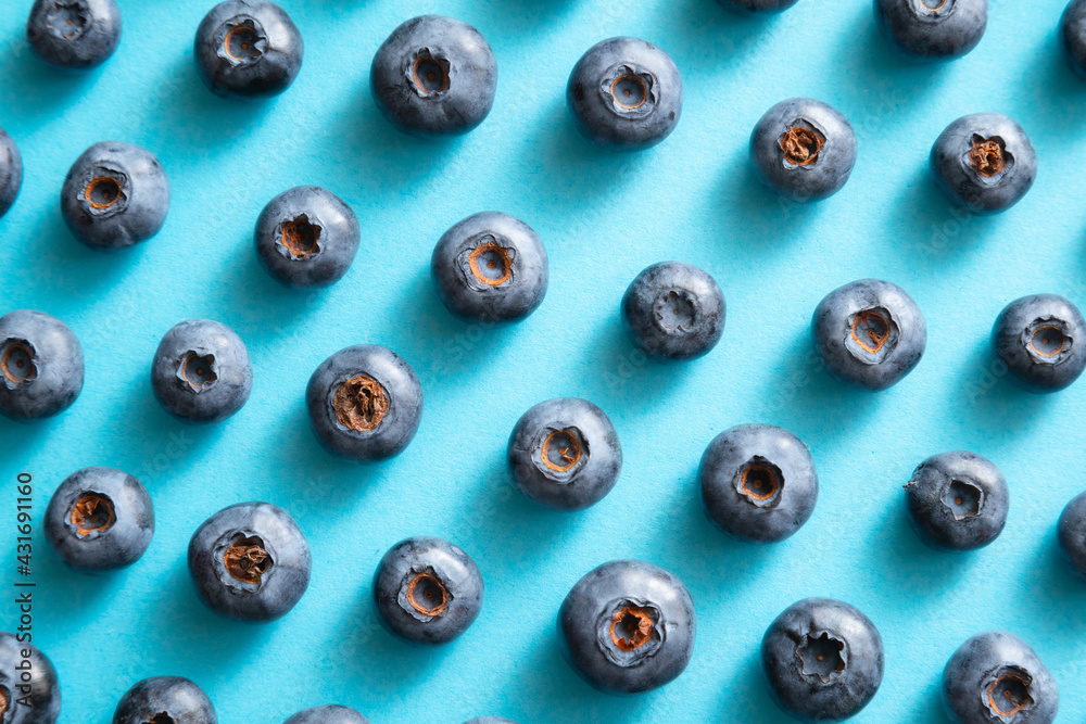 Blueberry pattern on blue background. Ripe blueberries texture close up. Blueberry pattern on blue background. Ripe blueberries texture close up.