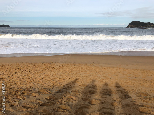 Four people's shadows on a beach in Umina, landscape